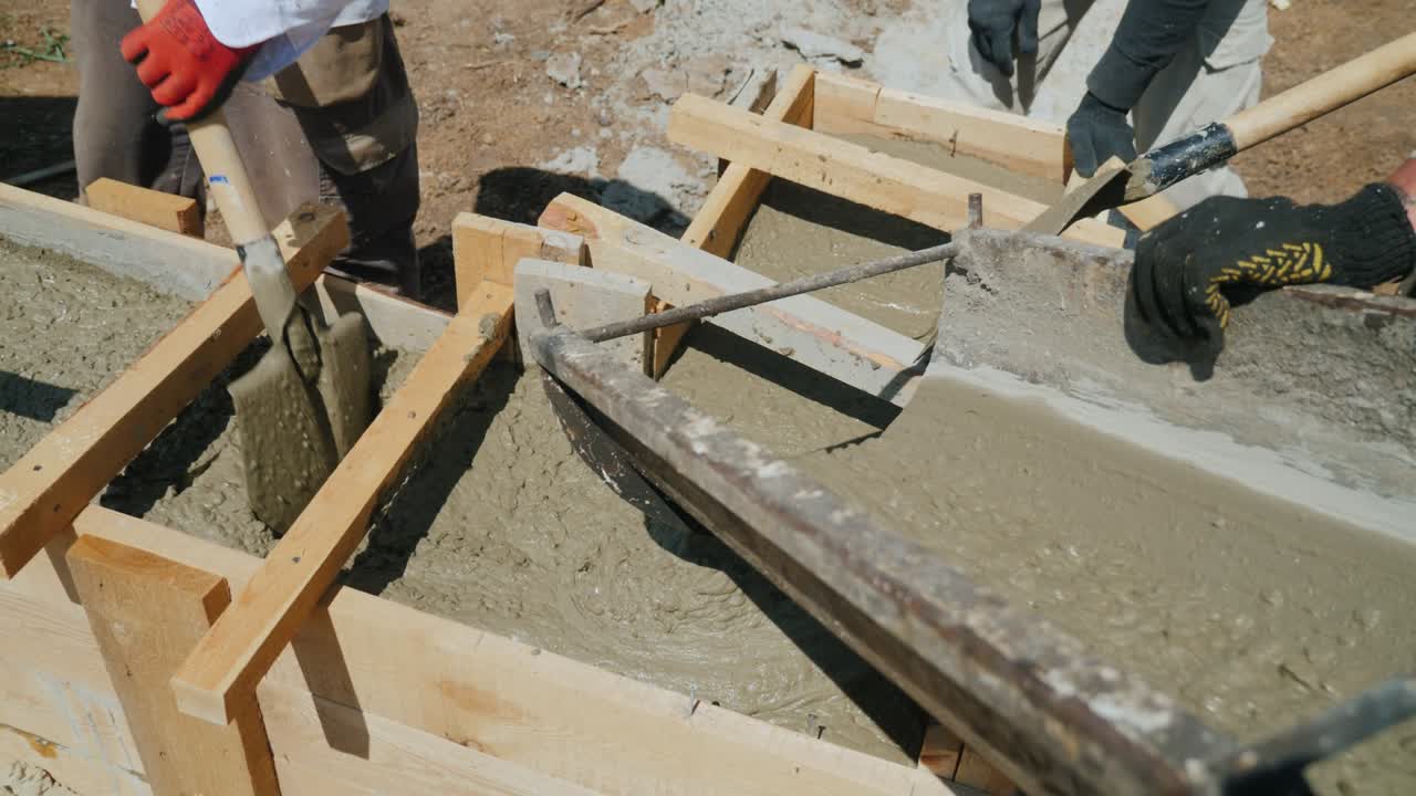 trabajar con hormigón en la construcción de una casa pequeña. hormigón líquido vertido en el encofrado de madera, hacer la base del edificio