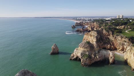 portimao rugged cliff coast with emerald ocean sea water, aerial view, portugal