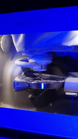 work of dental device. advanced milling machine in laboratory. dental machine carving out shape of human teeth. modern medical technologies. blue light. vertical video