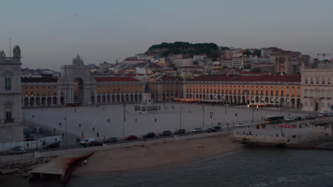 Close-up-low-aerial-view-of-Praca-do-Comercio-square-with-Arco-da-Rua-Augusta-monument-by-the-sea-in-city-center-of-Lisbon-in-the-evening