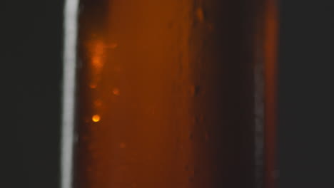 tirón de enfoque de primer plano de gotas de condensación en una botella de cerveza fría o bebida gaseosa