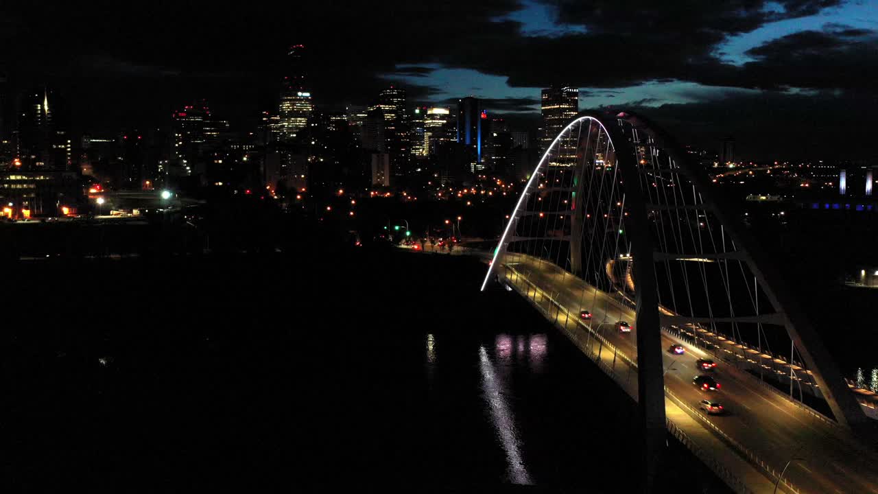 Aerial drone view of the Edmonton Walterdale Bridge over the North Saskatchewan River during a summer night and the downtown skyline in the background