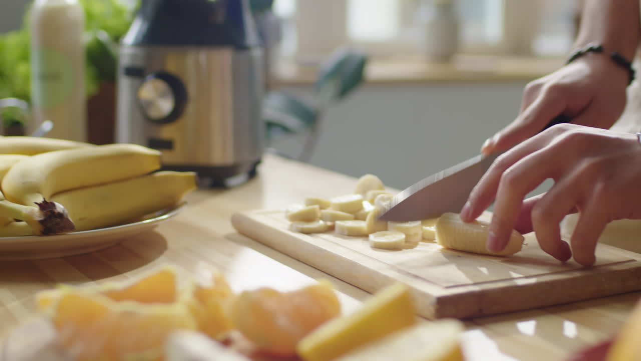 Hands of Man Cutting Banana for Making Smoothie