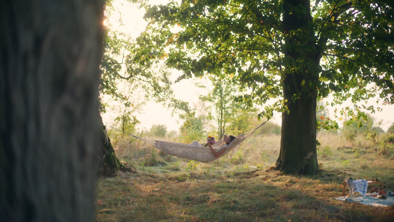 Young girl lost in thought on hammock evening