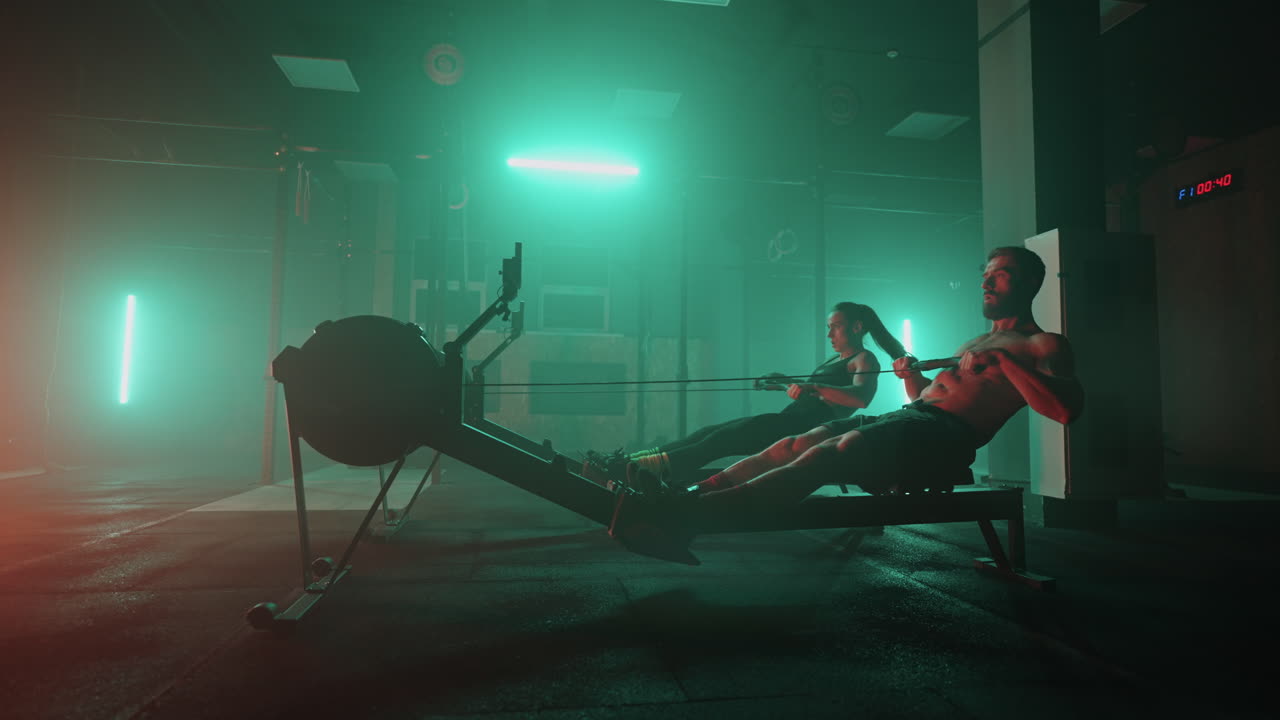 크로스피트 체육관 의 훈련 시 ⁇ 레이터 에서 근육적 인 남자 와 운동적 인 여자 의 운동. 근육적 인 스포츠 남자 와 여성 의 운동 시 ⁇ 레이터 에서 체육관 에서 운동 하는 여자 선수 들