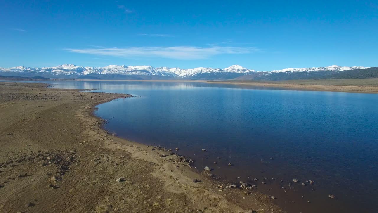 Et smukt luftfoto over en bjergsø viser Sierra Nevada-bjergene om vinteren.