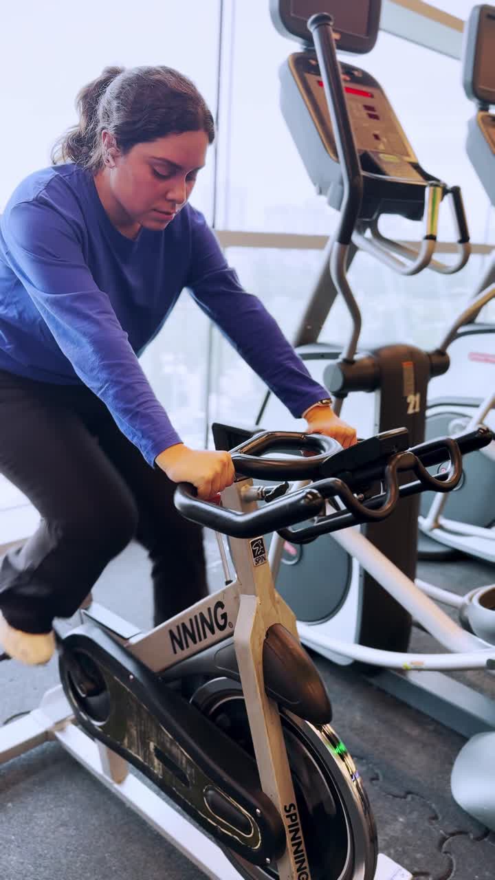 Giovane donna che fa spinning in palestra