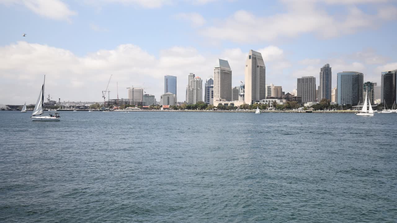 los barcos pasan por el océano con la ciudad de san diego, california, al fondo