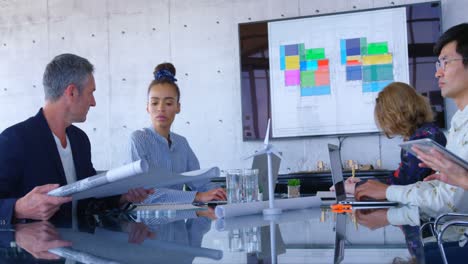 Mult-ethnic-business-people-discussing-over-blueprint-in-the-conference-room-at-modern-office-4-4k