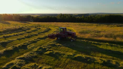 tractor cubriendo un campo al atardecer
