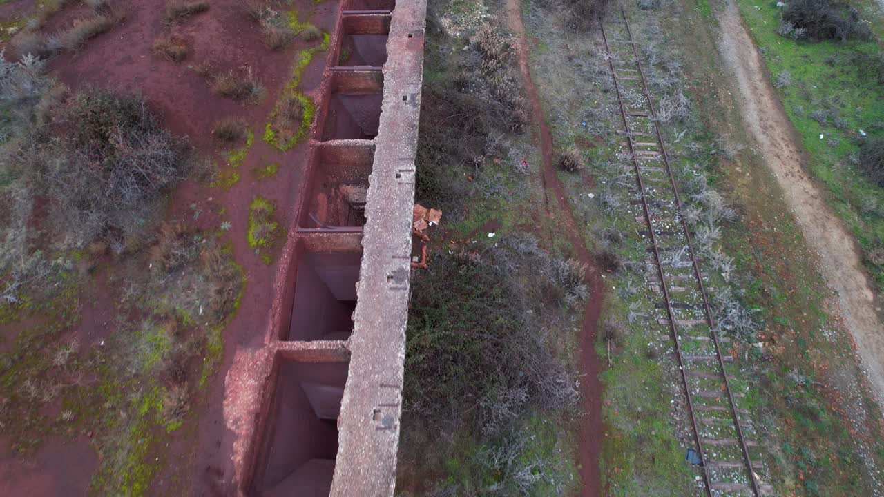 ferrocarril destruido que se utilizó para cargar mineral con una grúa en vagones de tren de mercancías en albania