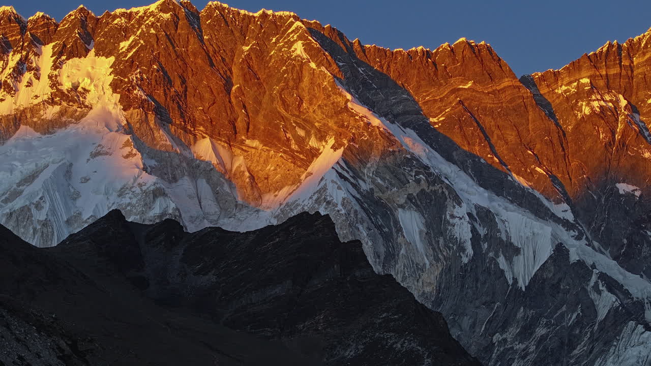 Timelapse panoramico dall'ora d'oro al tramonto sulle montagne dell'Himalaya nella regione dell'Everest in Nepal, che mostra drammatiche vette alpine sotto la mutevole luce serale.