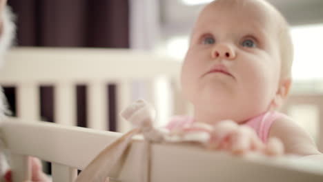 Adorable-baby-face-in-white-crib.-Lovely-kid-in-bed.-Beautiful-infant-face