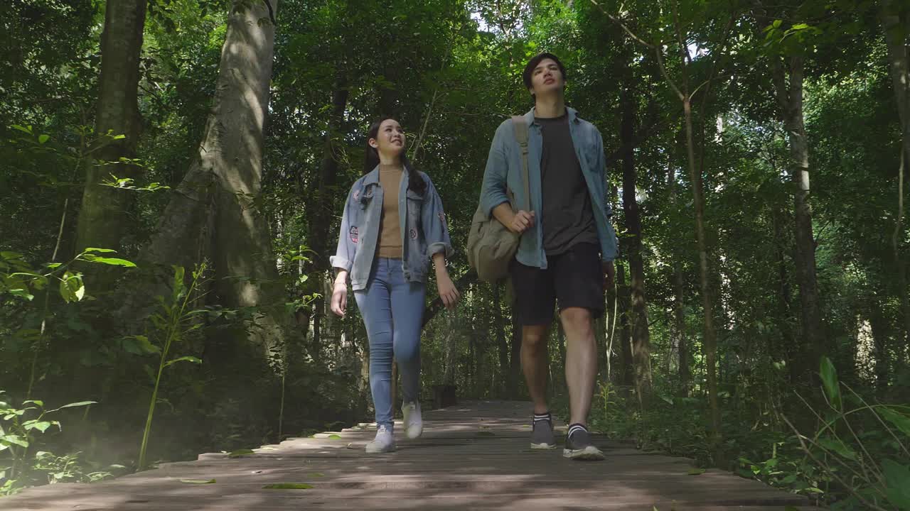 Couple Walking On Wooden Path In Tropical Forest, Slow Motion