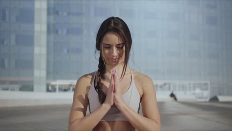 Mujer-Sonriente-Sentada-En-Pose-De-Loto-En-La-Calle-Urbana.-Chica-En-Forma-Meditando-Al-Aire-Libre