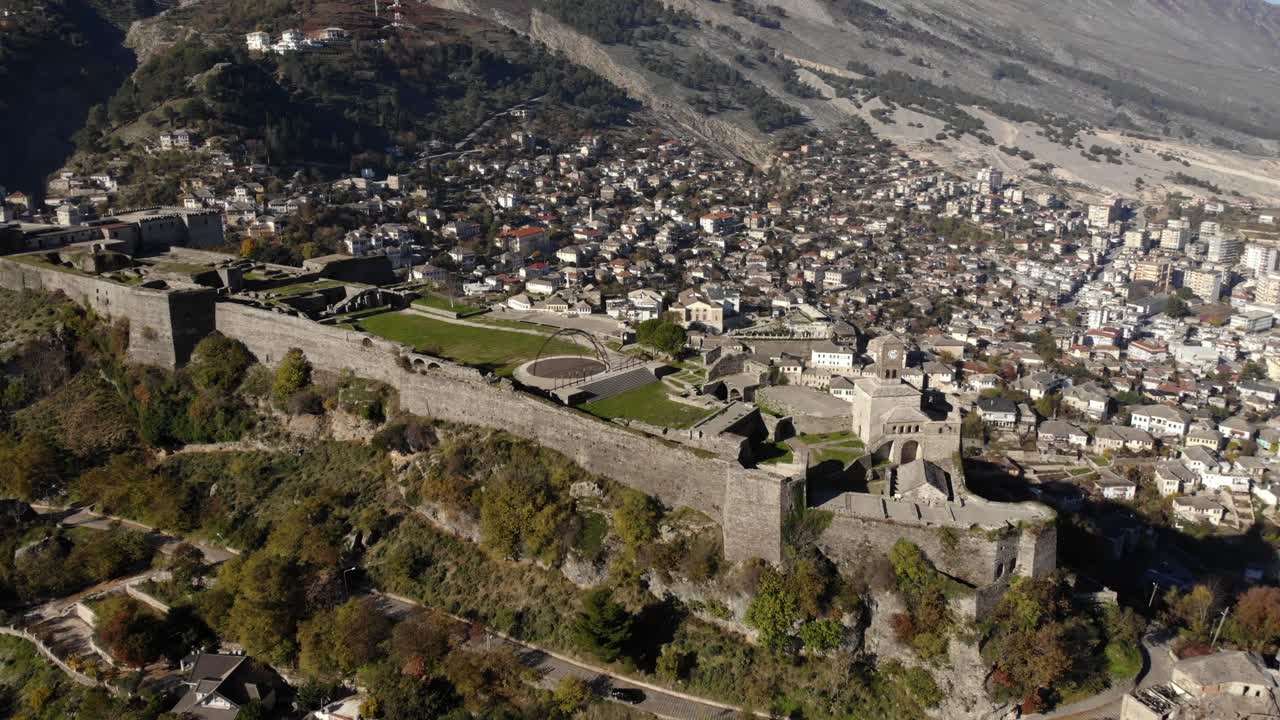 Mura in pietra della fortezza medievale di Gjirokaster costruita su una collina circondata da case cittadine