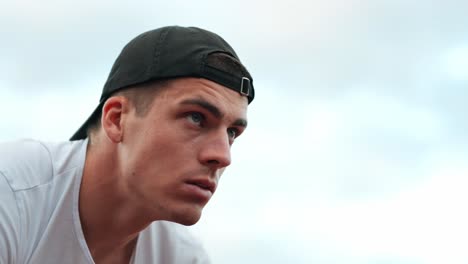 young male athlete with cap stares ahead intently, waiting for start signal of the athletic competition