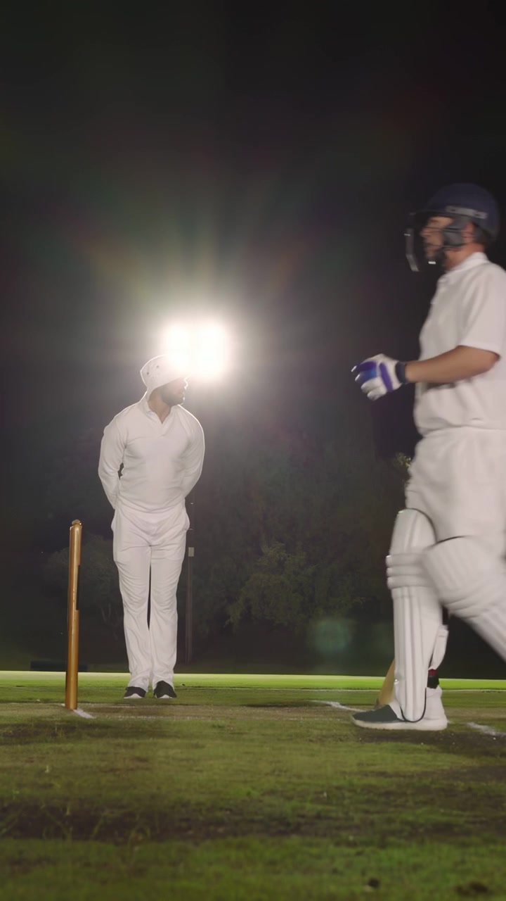 Vertikal video: Ved stumps kigger en batsman på lyset, sociale notifikationer forstyrrer scenen, går væk.