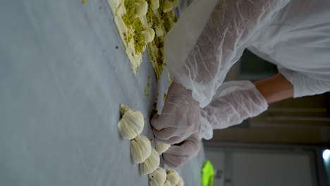 el pastelero turco prepara la baklava de ostras y la llena de crema y pistachos, video en cámara lenta, video vertical