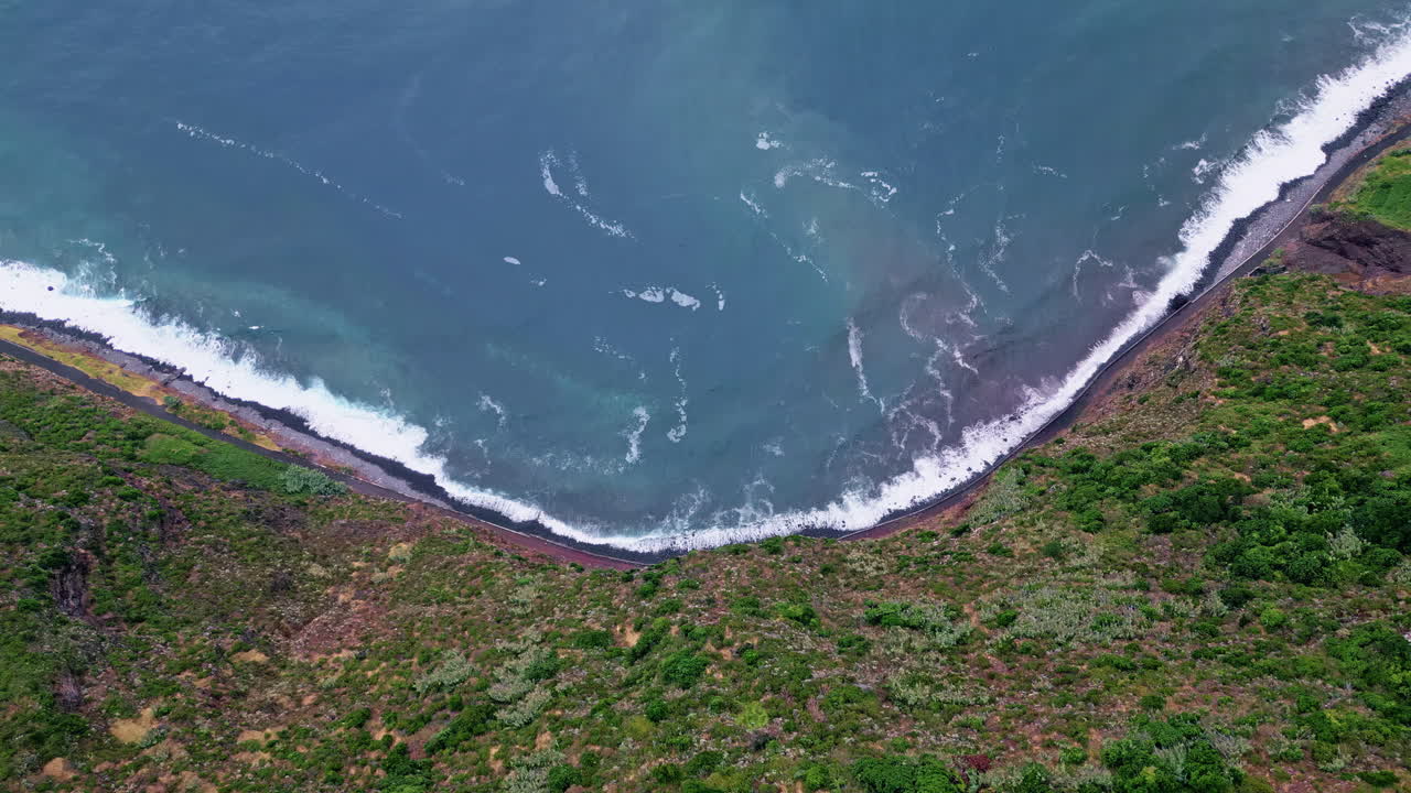 Mare turchese spumeggiante che si infrange su scogliere di pietra. Vista aerea dall'alto di montagne selvagge