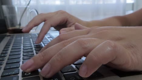 detailed front view close-up of hands on a laptop keyboard, fingers pressing keys