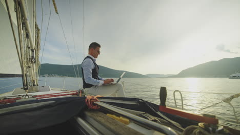 businessman working on a yacht at sunset