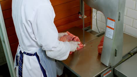 butcher cutting meat on meat cutting machine in shop 4k