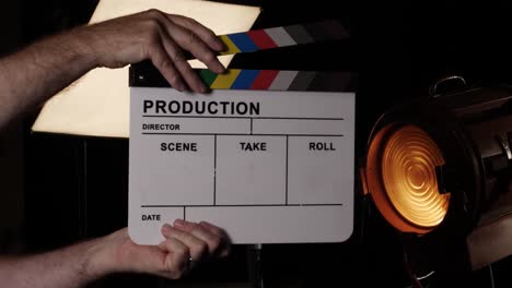 movie slate or clapboard raised into the frame and clapped in a movie studio