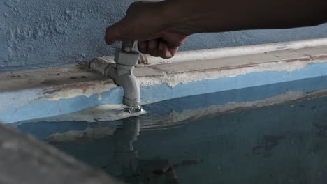 Persona-Cierra-Un-Grifo-De-Agua-Potable-En-El-Tanque-De-Almacenamiento