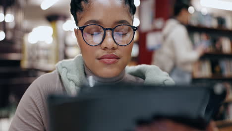 woman studying on a tablet in a library