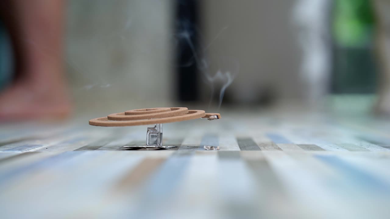 금속 스탠드 에 불타는 모기 나선