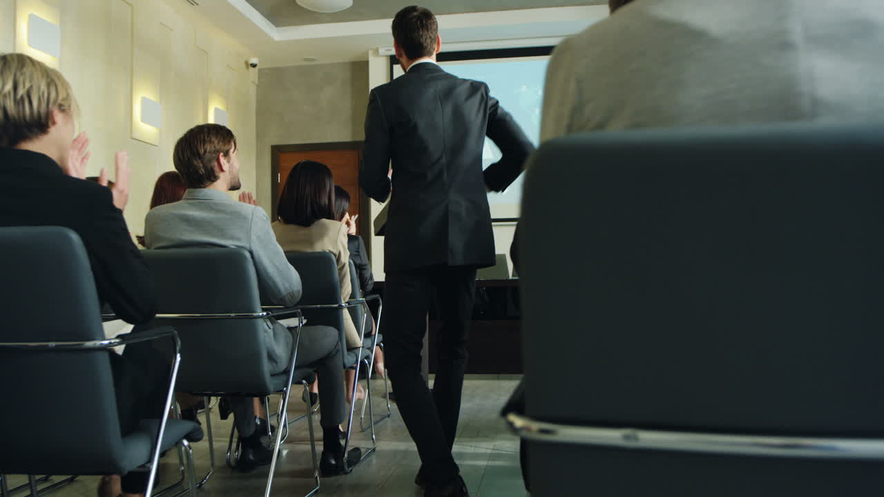 feliz empresário caucasiano terminando seu discurso na conferência na frente dos colegas e fazendo sim gesto ao sair