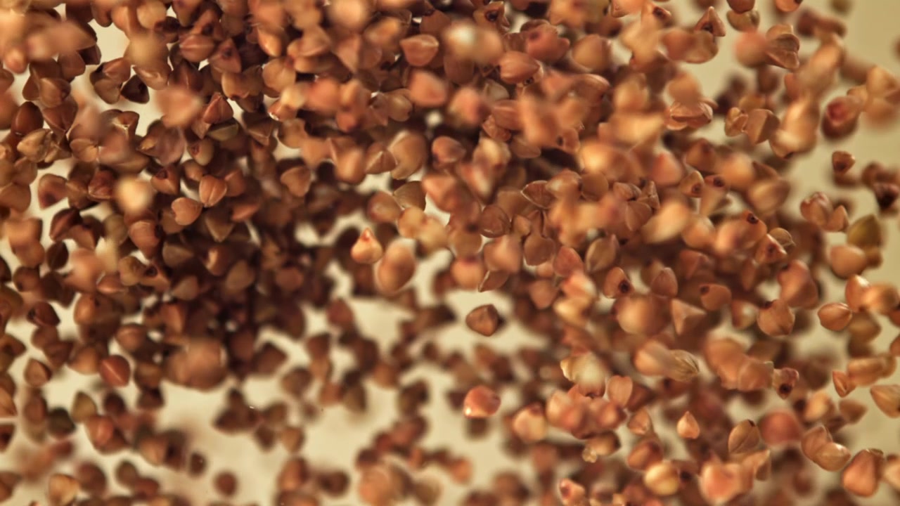 Grani di grano saraceno che cadono al rallentatore