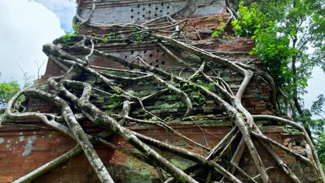 Inclinación-De-Una-Torre-Prasat-Pram-En-El-Templo-De-Koh-Ker,-Patrimonio-De-La-Unesco,-Raíces-Que-Envuelven-La-Arquitectura,-Camboya