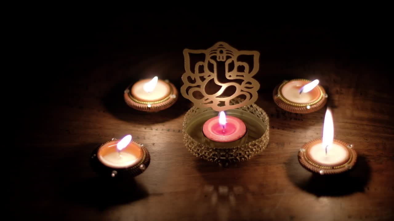 Shadow and light dance, play reflection on wooden table of Ganesha cutout, also Ganapati Vinayaka, one of the best-known and most worshipped deities in the Hindu pantheon, specially during Diwali