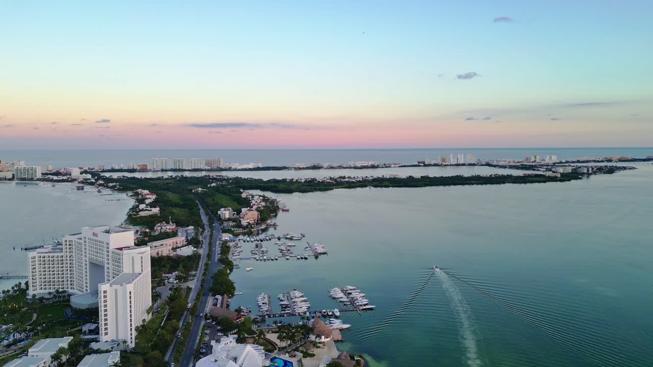 Cancun at sunset, showing a scenic coastline, hotels, and calm waters , aerial view