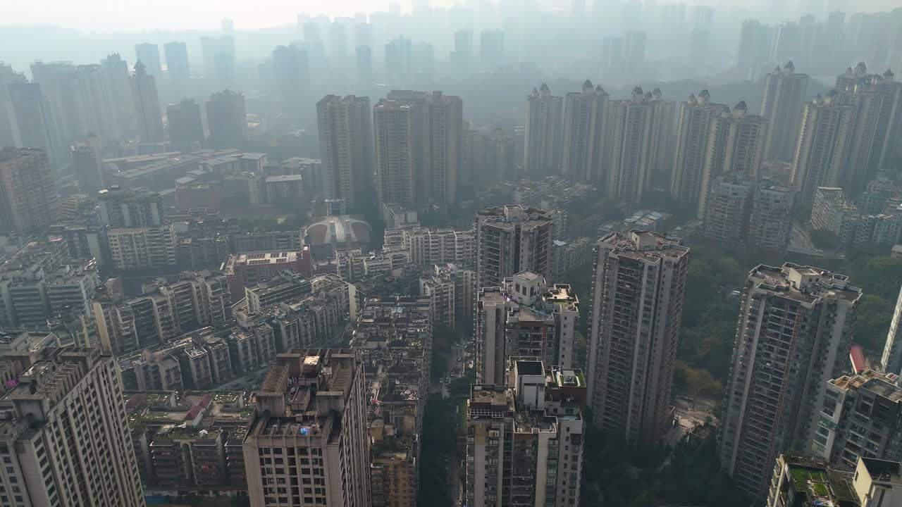 Uprising drone shot of a densely packed residential area in Chongqing, China, showcasing high-rise apartment buildings. Extreme Pollution.