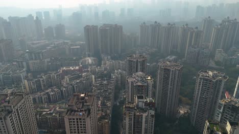 uprising drone shot of a densely packed residential area in chongqing, china, showcasing high-rise apartment buildings. extreme pollution.