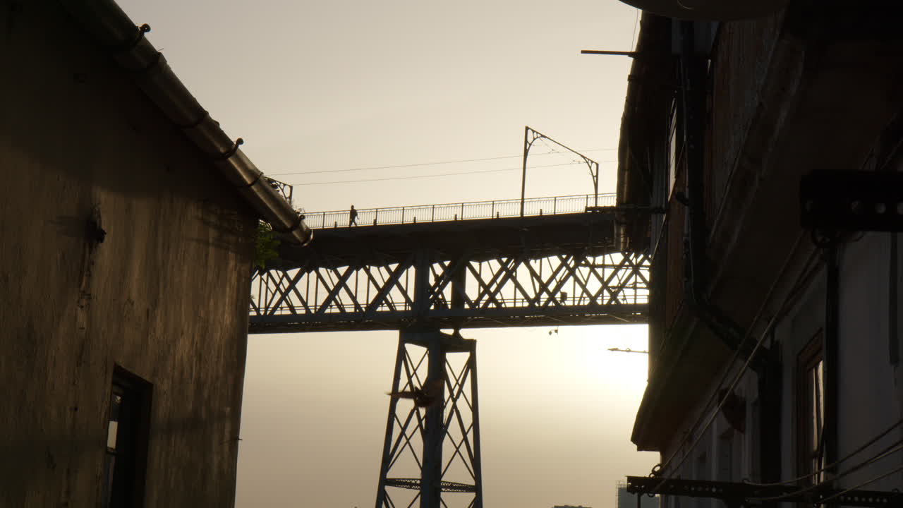 Person walking over Dom Luis I bridge in Porto, Portugal. Dramatic lighting view