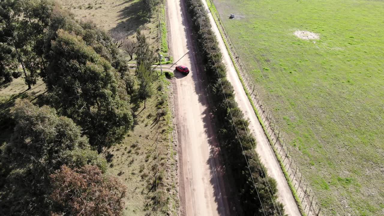 Ripresa aerea di un'auto che percorre una strada sterrata in campagna