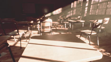 view to classroom with tables and small blackboard and grungy walls