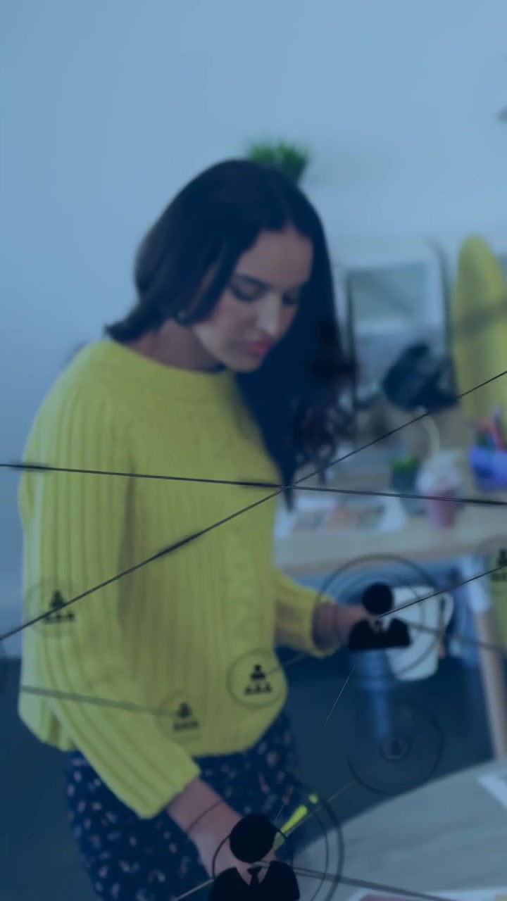 Donna in ufficio che si appoggia, visualizza documenti, cammina con una tazza e una matita gialla, con una sovrapposizione di rete che la oscura.
