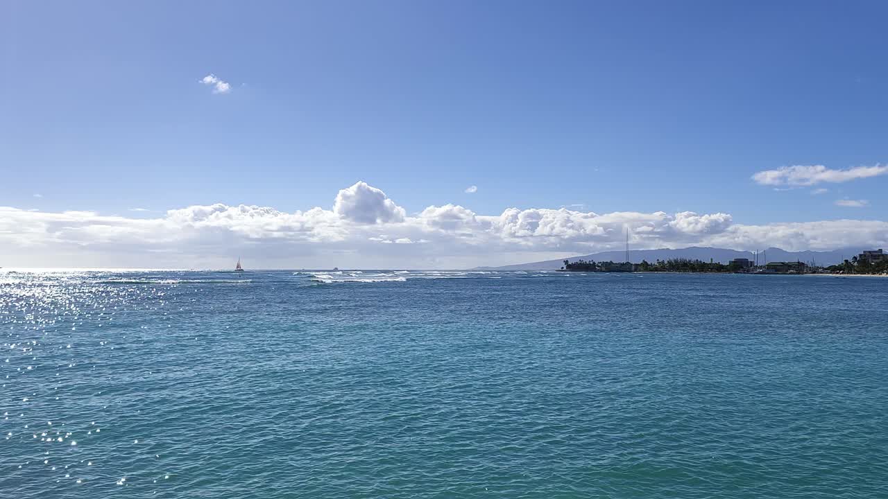 Splendida costa di Honolulu, Hawaii, con acqua turchese e nuvole bianche.