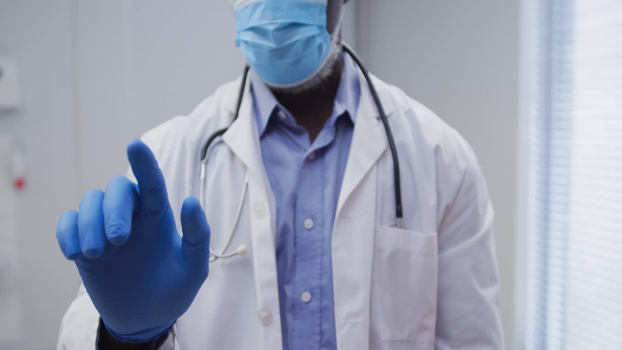 Metade do corpo de médico afro-americano usando máscara facial e luvas cirúrgicas