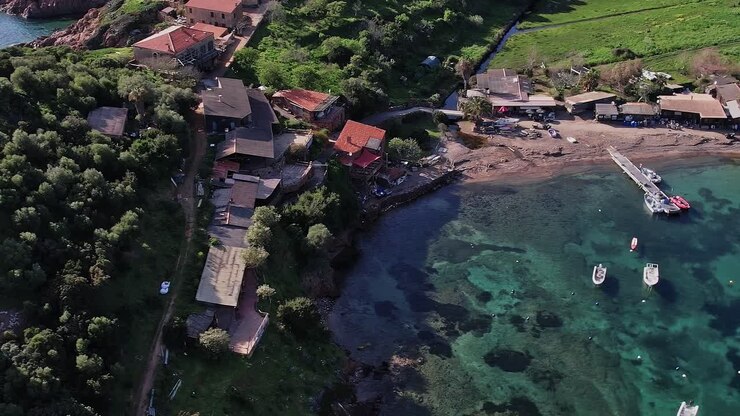 Costa della Corsica con case e acqua cristallina durante le ore diurne