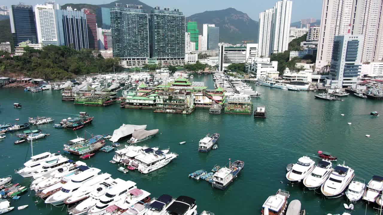 Time lapse Aerial view pullback shot of Po Chong Wan bay, Hong Kong, marina and Typhoon shelter with skyscrapers and hundreds of small boats on a clear Summer day.