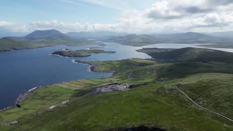 Valentia-island-with-geokaun-mountain-and-cliffs,-lush-greenery,-coastal-landscape,-during-daylight,-aerial-view