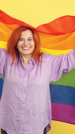 woman proudly holding a rainbow pride flag