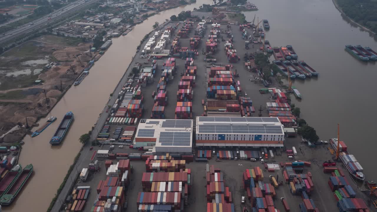 Hyperlapse over Saigon River container port in Ho Chi Minh City, Vietnam with interesting activity of moving vehicles, boats, and cranes