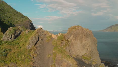 volando sobre la formación rocosa en la playa en nueva zelanda
